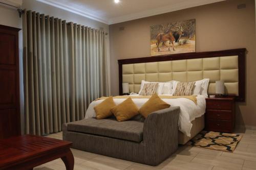 um quarto com uma cama grande e um sofá em Pemabwe Guest Lodge em Harare