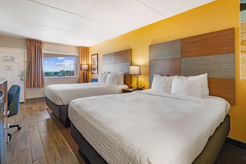 a hotel room with two beds and a window at Clarion Pointe Galveston - Beachfront in Galveston