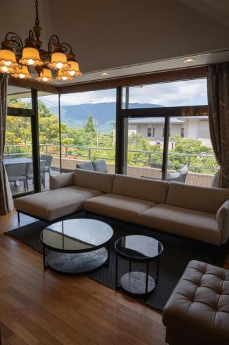 salon z kanapą i dużym oknem w obiekcie Villa Tombo Hakone w mieście Hakone
