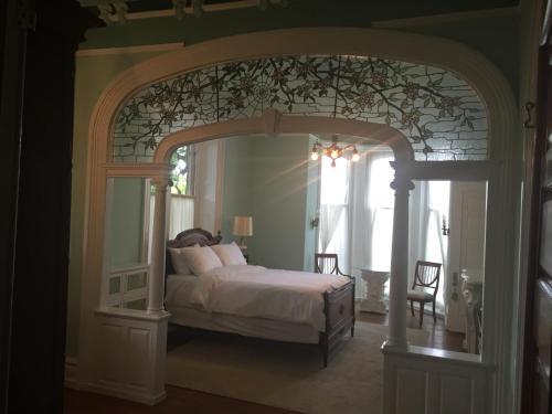 a bedroom with a large bed with an archway at The Inn at Centre Park in Reading