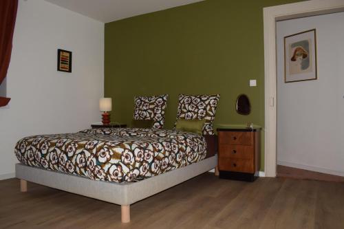 une chambre avec un lit et un mur végétal dans l'établissement Le 70s 2 pièces proche Colmar, à Holtzwihr