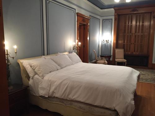 una camera da letto con un grande letto con lenzuola bianche di The Inn at Centre Park a Reading