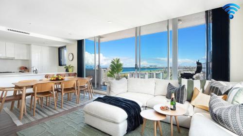 a living room with a white couch and a table and a kitchen at Burelli Beauty in Wollongong