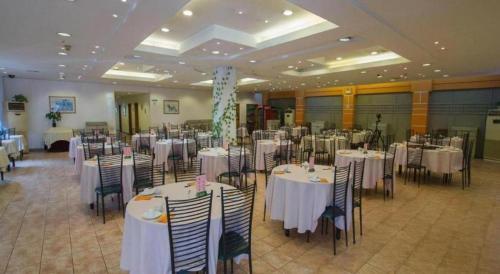 Un salón de banquetes con mesas y sillas blancas. en Jinjiang Inn Select Shanghai Pudong Airport, en Shanghái