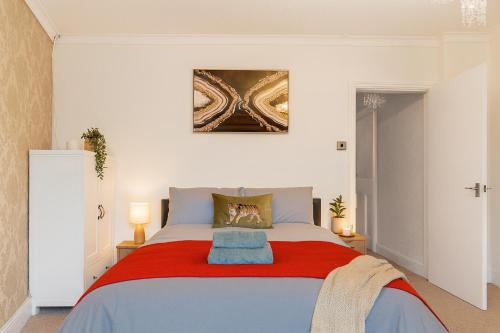 een slaapkamer met een groot bed met een rode deken bij Workington Haven - 3 Bed Home in Workington