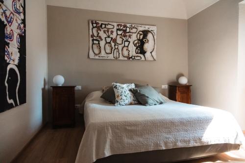 a bedroom with a bed and a painting on the wall at Cottage di design con giardino in Bosco Marengo