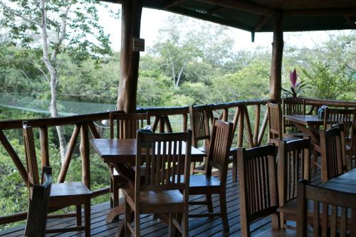 a porch with tables and chairs and a view at Cañon de la Vieja Lodge in Liberia