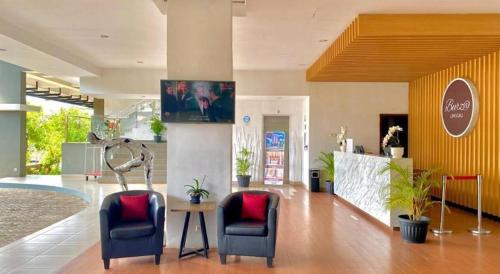 um átrio com duas cadeiras e uma mesa num edifício em Burza Hotel Lubuk Linggau em Lubuklinggau