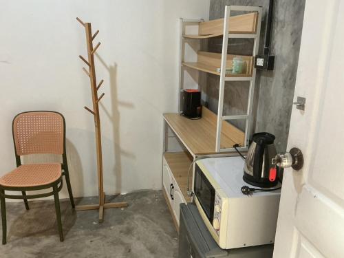 eine kleine Küche mit Mikrowelle und Stuhl in der Unterkunft BN Residence in Ko Tao