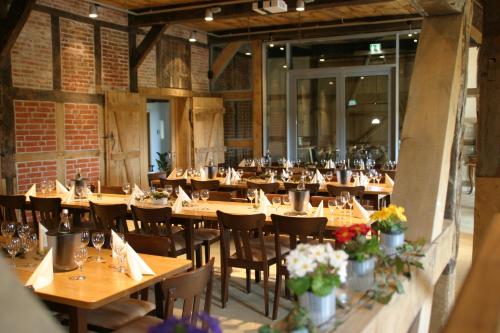 une salle à manger avec des tables et des chaises en bois dans l'établissement Hof Viehbrook, à Hollenbek