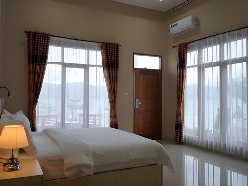 Postel nebo postele na pokoji v ubytování Samosir Cottages Resort