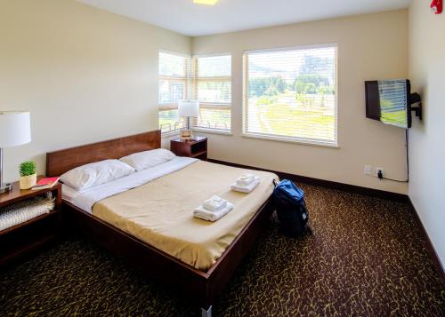 una camera da letto con un letto con due asciugamani sopra di HI Whistler - Hostel a Whistler