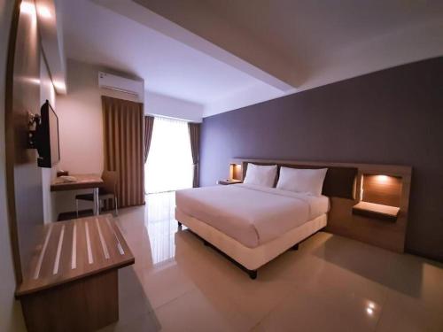 Un pat sau paturi într-o cameră la My Tower Hotel Surabaya
