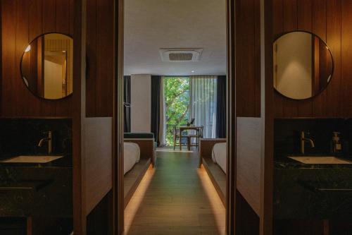 a bathroom with two beds and two sinks and mirrors at Good Ol' Days Hotel in Busan
