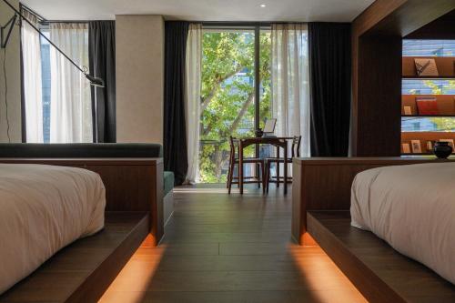 a hotel room with two beds and a window at Good Ol' Days Hotel in Busan