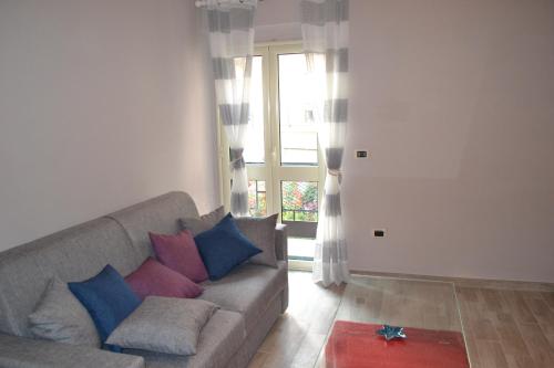 a living room with a gray couch with colorful pillows at Fiordaliso in Caulonia Marina