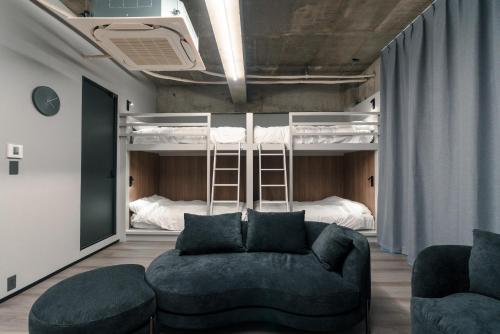 東京にあるVisionary Stay HINODEのソファと二段ベッドのあるリビングルーム