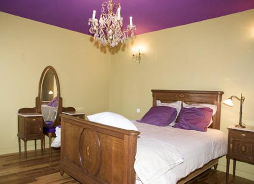 a bedroom with a bed and a chandelier at Gite Bobinou in Lisbourg