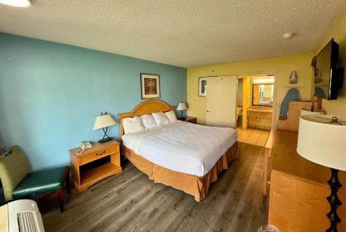 a hotel room with a bed and a bathroom at Days Inn by Wyndham Ruther Glen Kings Dominion Area in Ruther Glen