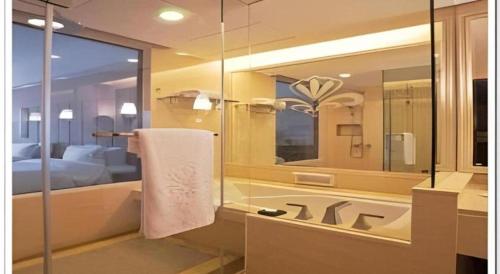 ein Bad mit einer Badewanne und einem Handtuch in der Unterkunft Putian Haiyuan International Hotel in Putian