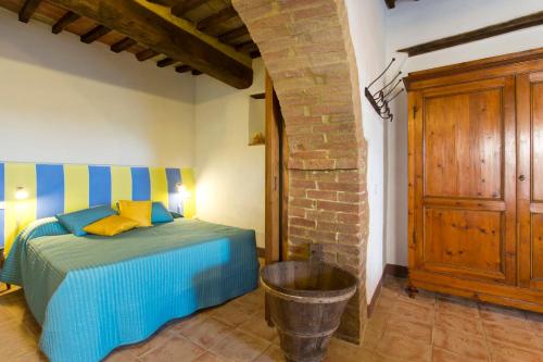 a bedroom with a bed with blue and yellow pillows at Casa vacanza vicolo degli orti in Monticiano