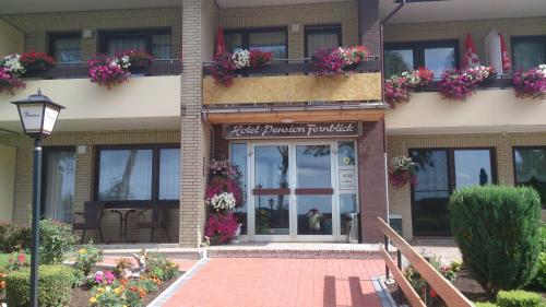 a building with flower boxes on the side of it at Hotel Pension Fernblick in Sankt Andreasberg