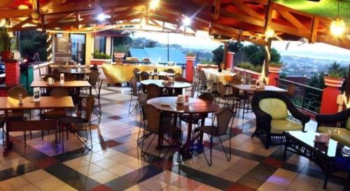 a restaurant with tables and chairs on a tiled floor at Satria Wisata Hotel in Parepare