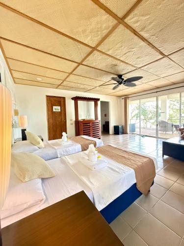 a large bedroom with two beds and a ceiling at Chindonan Dive and Beach Resort in Coron