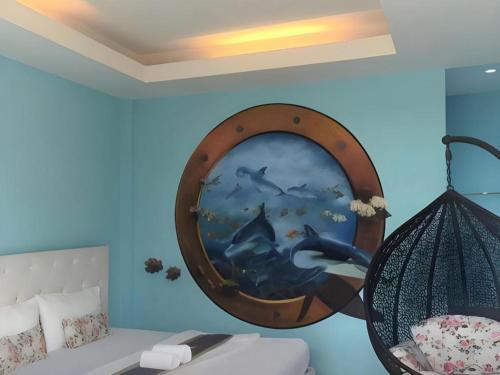 une pièce avec un miroir rond sur un mur bleu dans l'établissement Sixty-nine Resort, à Ban Tha Khwai