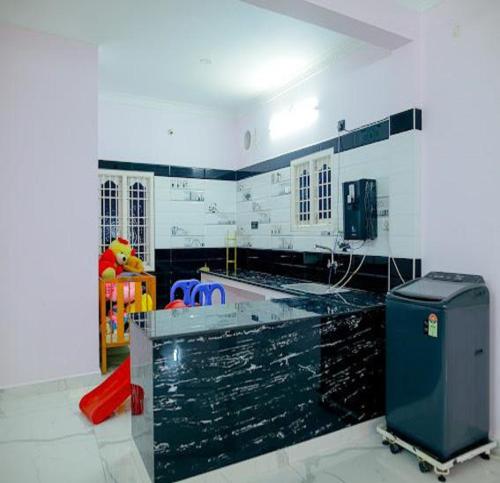 uma cozinha com uma bancada preta em um cômodo em The Sunshine Villa em Pondicherry