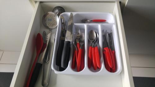a drawer filled with utensils in a white container at Apartamento Manaus Arena da Amazonia in Manaus