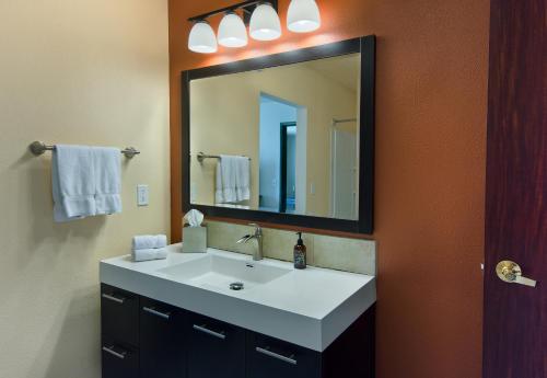 uma casa de banho com um lavatório branco e um espelho. em Oxford Suites Spokane Valley em Spokane Valley