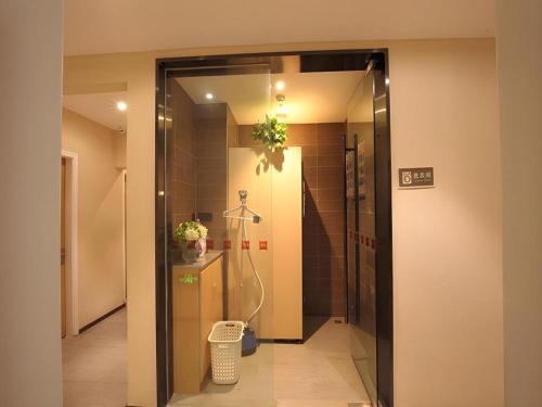 une salle de bain avec douche et porte vitrée dans l'établissement Ibis Ya An Langqiao, à Shaping