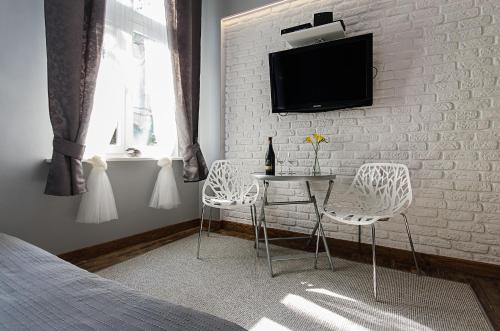 una camera da letto con tavolo, sedie e TV di Apartament Wierzbięcice a Poznań