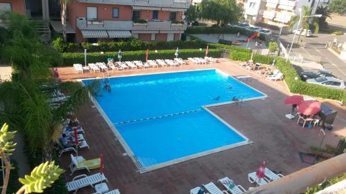 an overhead view of a large swimming pool with chairs and umbrellas at Casa Linda Taormina Etna in Fondachello