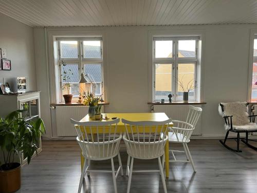 una sala da pranzo con tavolo e sedie gialli di Solskinshuset a Hasle