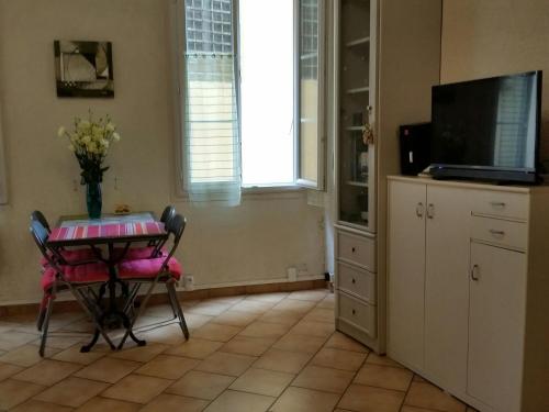 uma cozinha com uma mesa com um vaso de flores em Cosy Studio climatisé Vieux Nice proche mer et toutes commodités em Nice