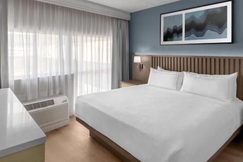 ein Schlafzimmer mit einem großen weißen Bett und einem Fenster in der Unterkunft DoubleTree by Hilton Hotel South Bend in South Bend