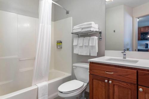 une salle de bain avec toilettes, lavabo et douche dans l'établissement MainStay Suites Emporia, à Emporia