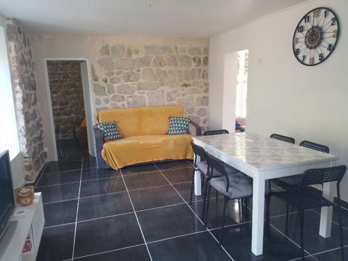 a living room with a table and a couch at Gîte au cœur des Gorges du Tarn in Saint-Rome-de-Dolan