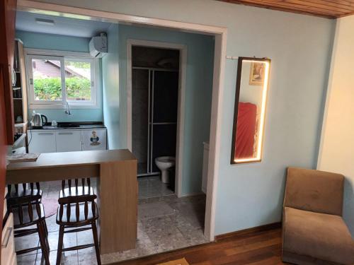 a kitchen with a counter and stools in a room at Casa Villagio - CONDOMÍNIO in Gramado