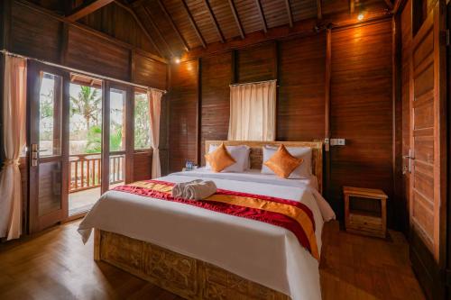 a bedroom with a large bed in a wooden room at The Aura Penida Hills By Bali Cabin in Nusa Penida