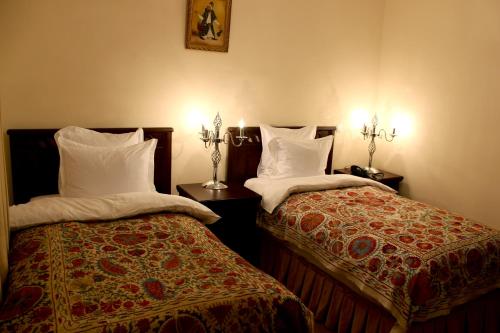 two beds sitting next to each other in a room at L'Argamak in Samarkand
