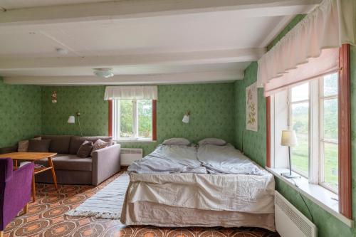 a bedroom with a bed and a couch at Horsvik - Hagstugan in Studsvik