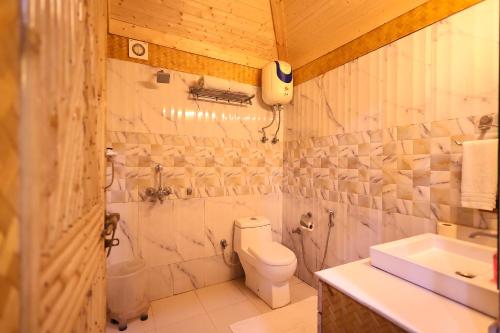 a white bathroom with a toilet and a sink at Foxoso Misty Oaks - Hotel & Resort in Bhowāli