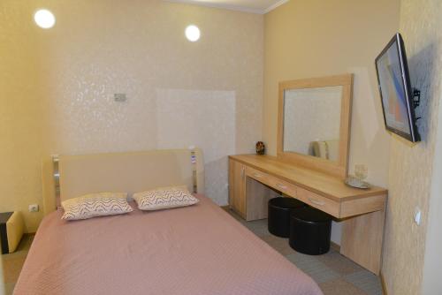 a bedroom with a bed and a vanity and a mirror at Motel Carmen in Baia Mare