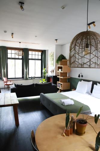 a bedroom with a bed and a couch and a table at Stadslogement Valentijn in Sneek