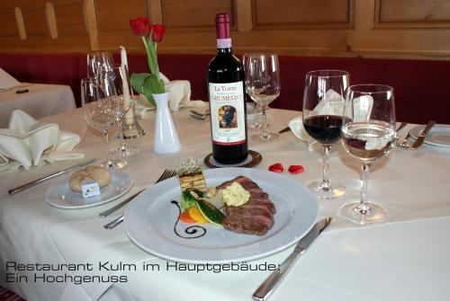 Kessler's Kulm Gästehaus في دافوس: طاولة مع طبق من الطعام وزجاجة من النبيذ