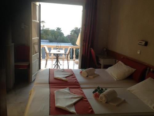 a bedroom with two beds and a view of a patio at Alkyonis Apartments in Panormos Kalymnos