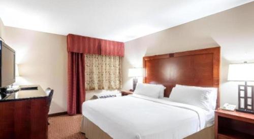 ein Hotelzimmer mit einem großen Bett und einem Fernseher in der Unterkunft White Peak Hotel – Frisco By IHG in Summit Medical Center Heliport